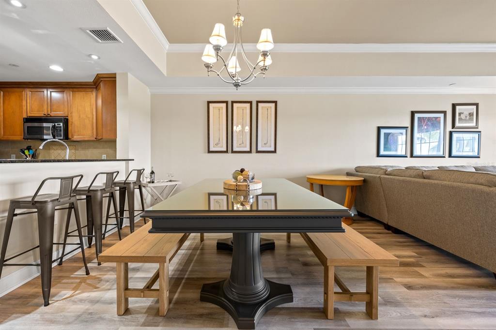 1370 Centre Ct Ridge Drive, Unit 401 Reunion, FL 34747 - Photo 13 of 51 a view of a dining room with furniture a chandelier and wooden floor