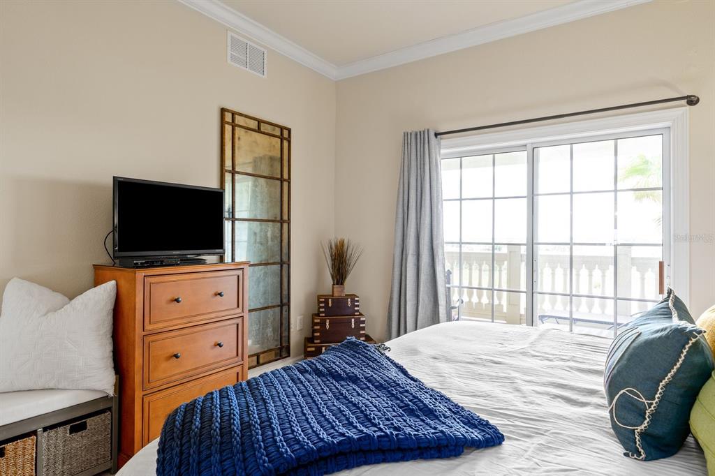 1370 Centre Ct Ridge Drive, Unit 401 Reunion, FL 34747 - Photo 18 of 51 a bedroom with a bed and a flat screen tv
