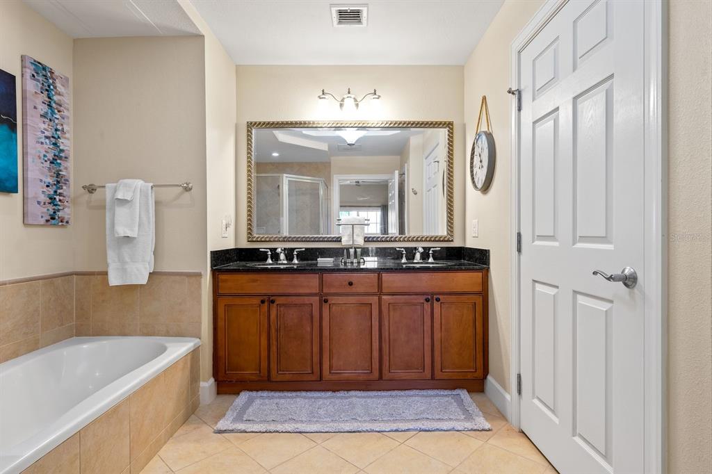 1370 Centre Ct Ridge Drive, Unit 401 Reunion, FL 34747 - Photo 20 of 51 a spacious bathroom with a bathtub sink and mirror