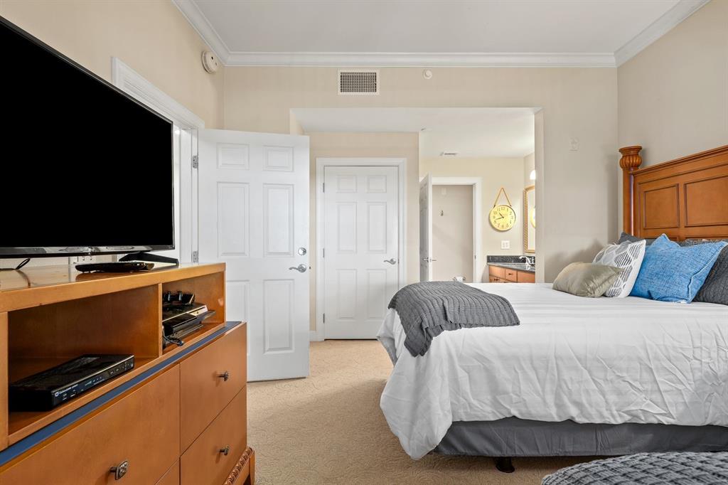 1370 Centre Ct Ridge Drive, Unit 401 Reunion, FL 34747 - Photo 23 of 51 a bedroom with a bed and a flat screen tv