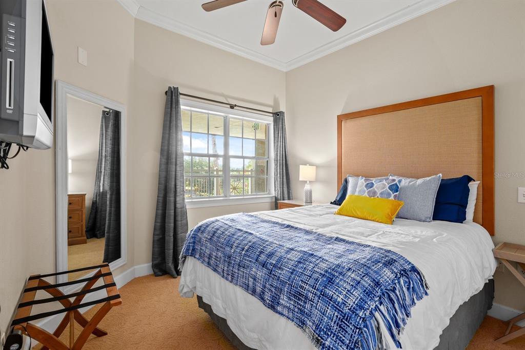1370 Centre Ct Ridge Drive, Unit 401 Reunion, FL 34747 - Photo 26 of 51 a bedroom with a bed and glass windows