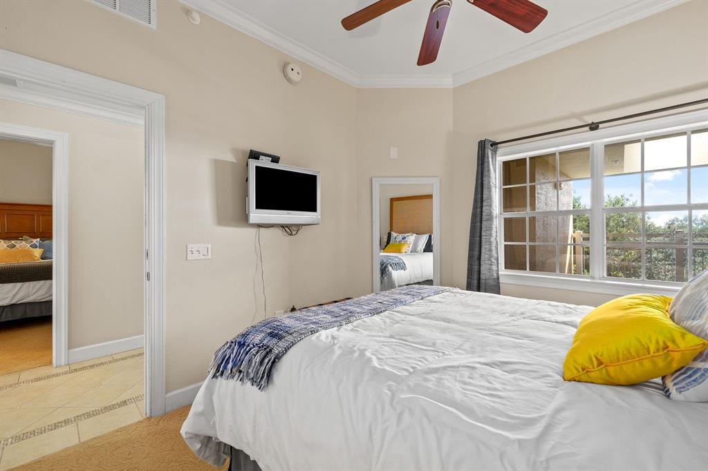 1370 Centre Ct Ridge Drive, Unit 401 Reunion, FL 34747 - Photo 27 of 51 a bedroom with a bed and a flat tv screen