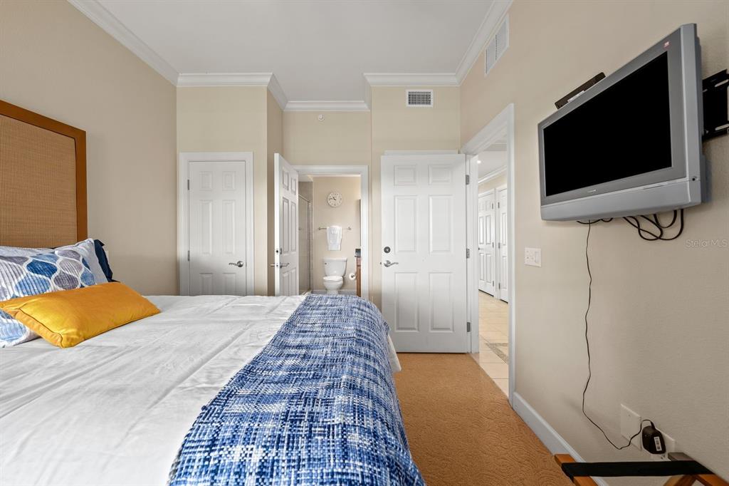 1370 Centre Ct Ridge Drive, Unit 401 Reunion, FL 34747 - Photo 28 of 51 a bedroom with a bed and a flat screen tv