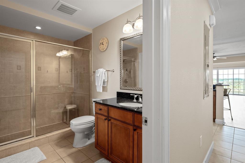 1370 Centre Ct Ridge Drive, Unit 401 Reunion, FL 34747 - Photo 29 of 51 a bathroom with a granite countertop sink toilet and shower