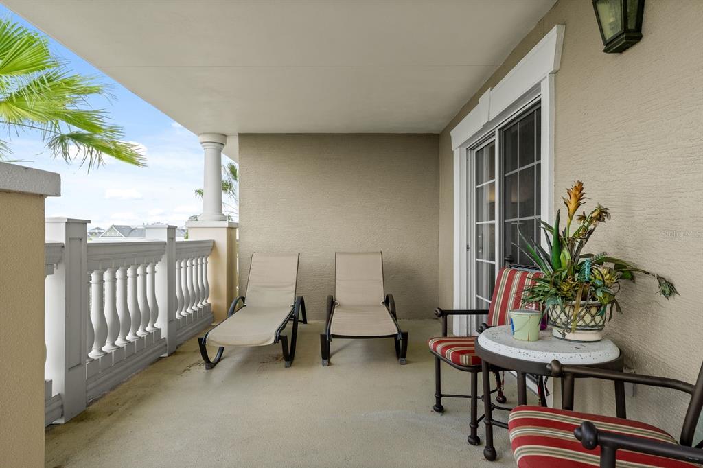 1370 Centre Ct Ridge Drive, Unit 401 Reunion, FL 34747 - Photo 33 of 51 a balcony with table and chairs