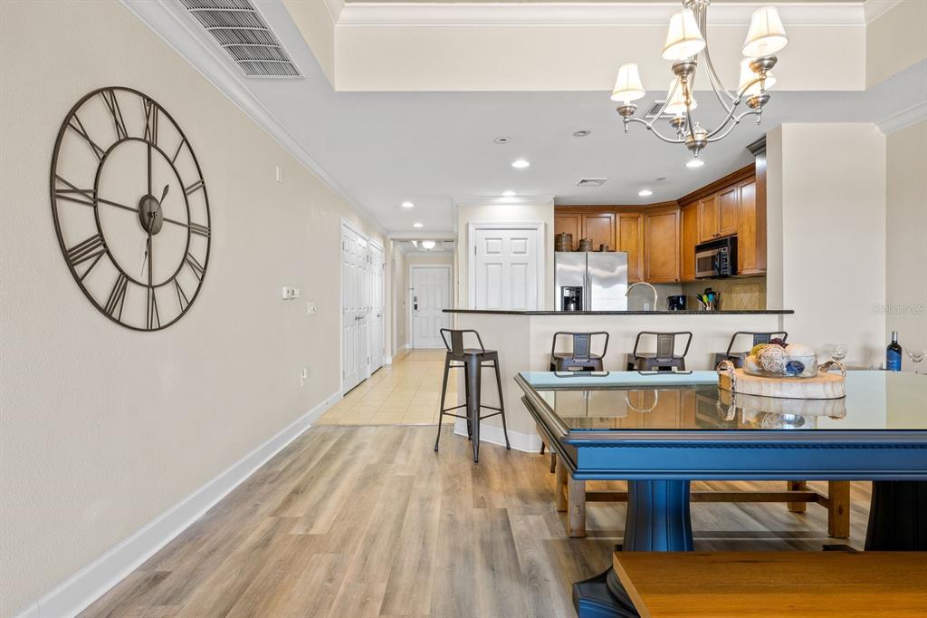 1370 Centre Ct Ridge Drive, Unit 401 Reunion, FL 34747 - Photo 6 of 51 a dining room with wooden floor a chandelier a wooden table and chairs