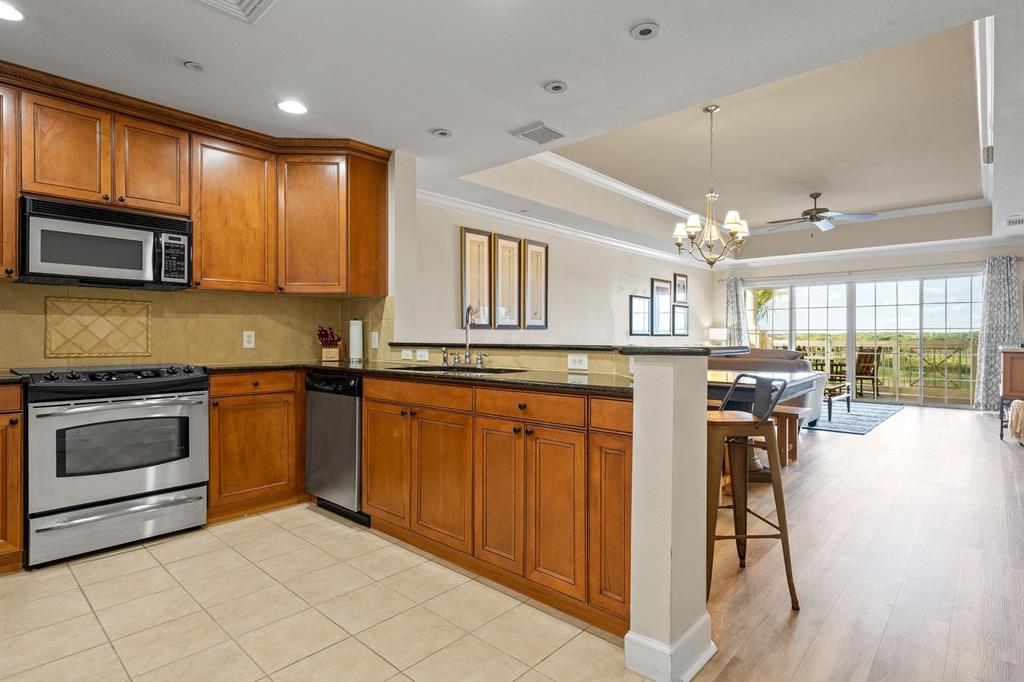 1370 Centre Ct Ridge Drive, Unit 401 Reunion, FL 34747 - Photo 8 of 51 a kitchen with stainless steel appliances kitchen island granite countertop a stove and cabinets