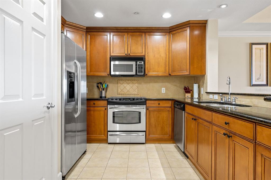 1370 Centre Ct Ridge Drive, Unit 401 Reunion, FL 34747 - Photo 9 of 51 a kitchen with stainless steel appliances granite countertop a stove a sink and a microwave