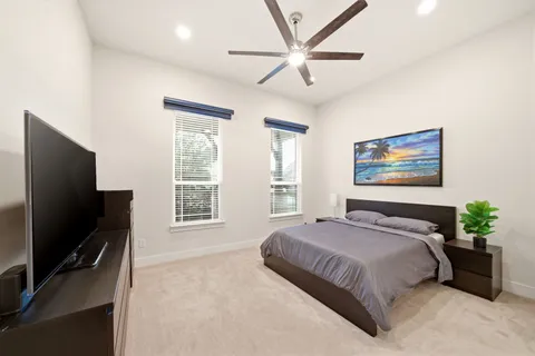 a bedroom with a bed a dresser and a flat screen tv