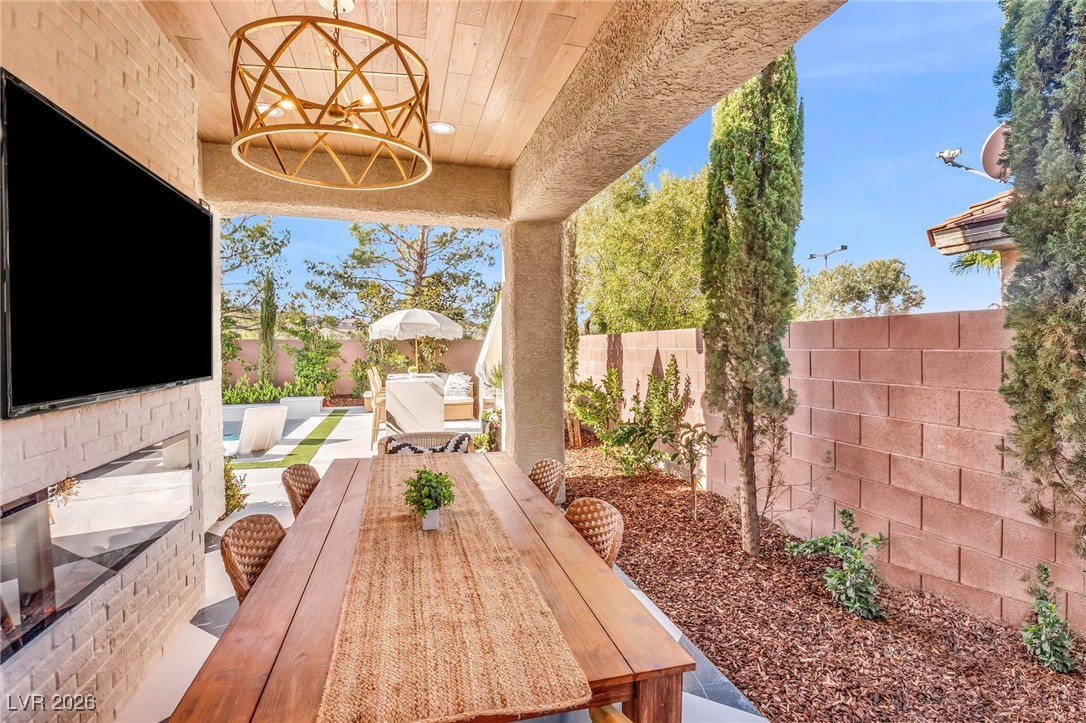2709 Rue Toulouse Avenue Henderson, NV 89044 - Photo 33 of 43 Backyard Covered Patio Area with Seating and TV/Fireplace