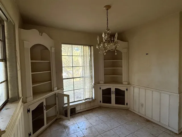 a view of an empty room with a fireplace and a window