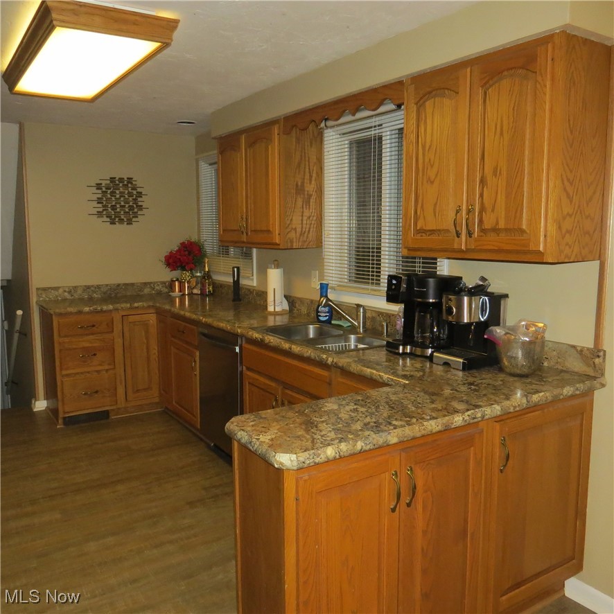 46580 Middle Ridge Road Amherst, OH 44001 - Photo 26 of 38 Kitchen with wood finish cabinets, stainless steel dishwasher, dark wood finished floors, and dark stone countertops