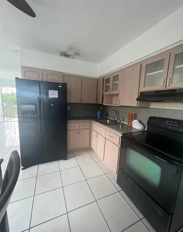 a kitchen with granite countertop a refrigerator and a sink