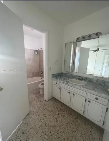 a bathroom with a granite countertop sink mirror and toilet