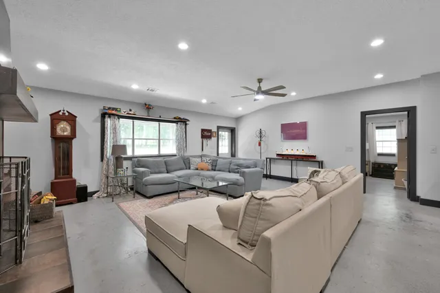 a living room with stainless steel appliances kitchen island granite countertop furniture and a refrigerator