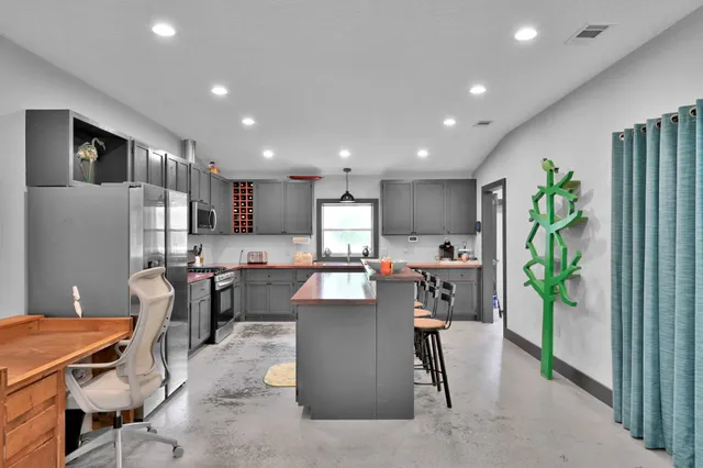 a kitchen with stainless steel appliances granite countertop a stove a sink and a refrigerator