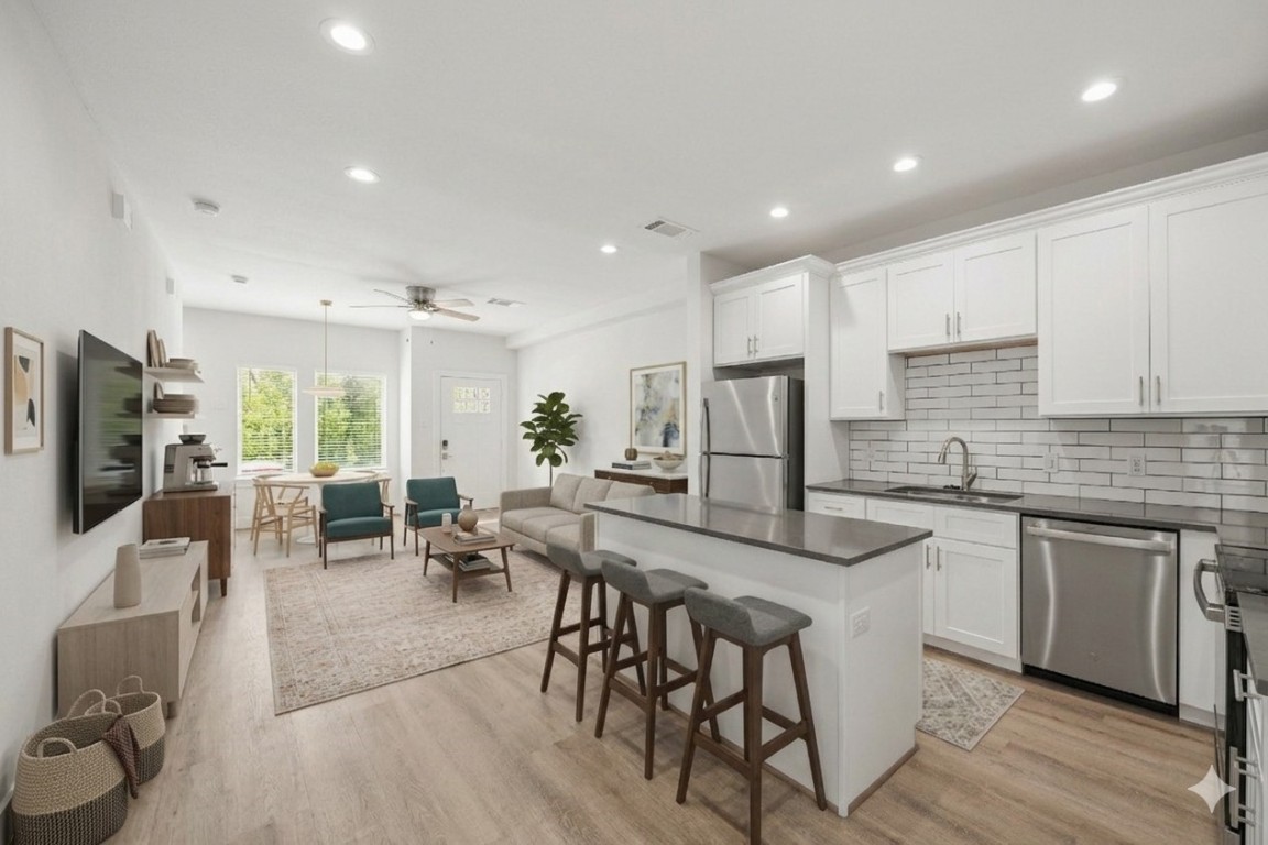 4007 New Orleans Street, Unit B Houston, TX 77020 - Photo 3 of 20 a kitchen with stainless steel appliances granite countertop a stove a sink a refrigerator a microwave oven with a dining table and chairs