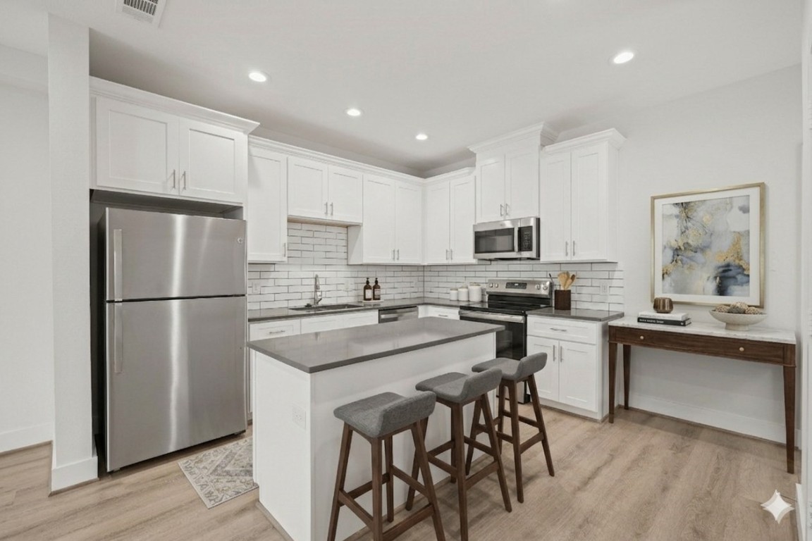 4007 New Orleans Street, Unit B Houston, TX 77020 - Photo 5 of 20 a kitchen with stainless steel appliances granite countertop a refrigerator a stove a sink a dining table and chairs