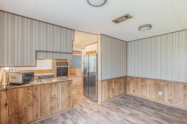 a kitchen with stainless steel appliances granite countertop a refrigerator and a stove top oven