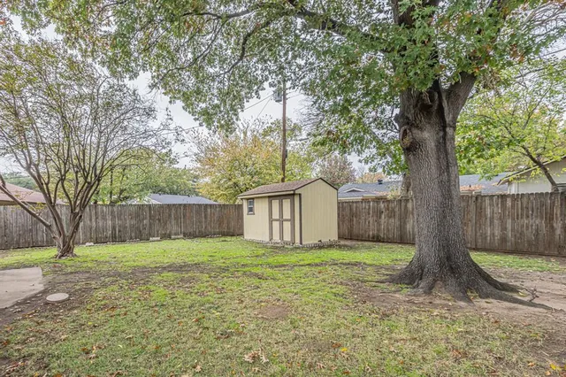 a view of a backyard with a small cabin and a chair