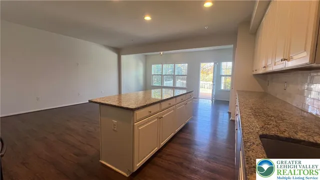 a kitchen with granite countertop a stove a sink and a refrigerator