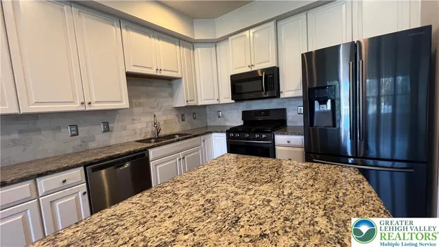 a kitchen with stainless steel appliances granite countertop a refrigerator stove and microwave