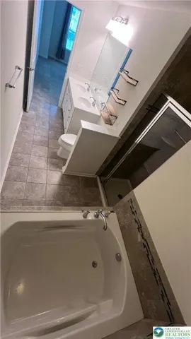 a view of an empty room with closet and a window