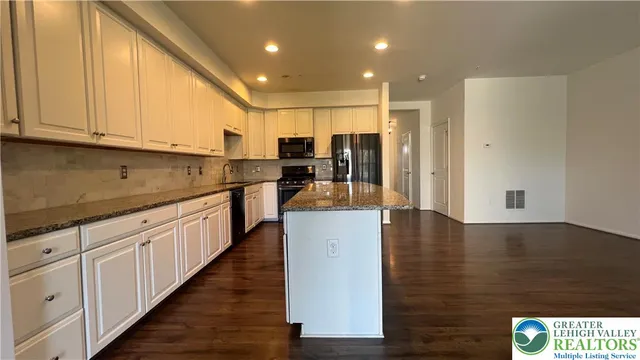 a kitchen with counter top space and wooden floor