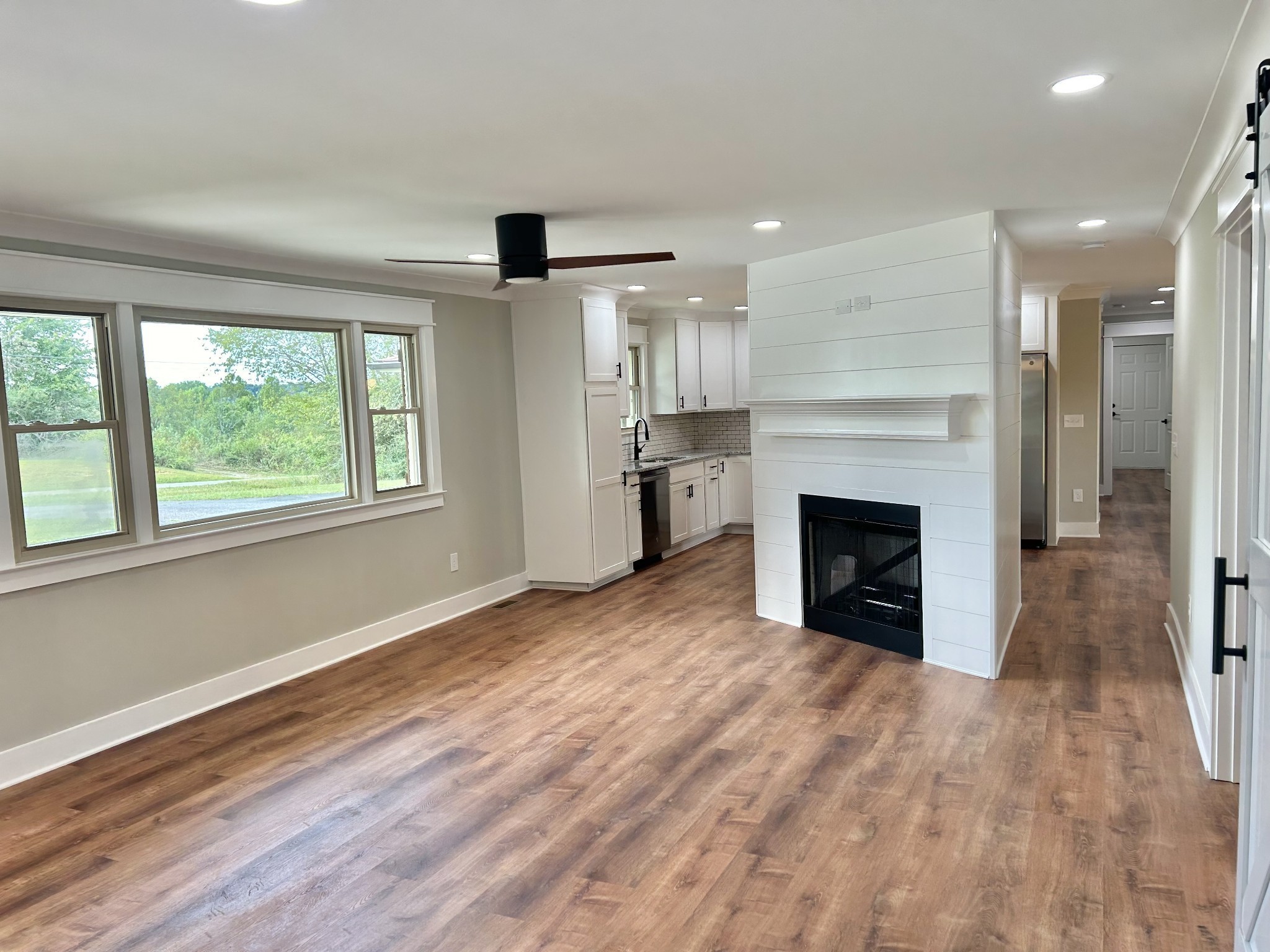 3786 Gnat Hill Road Manchester, TN 37355 - Photo 11 of 71 an empty room with windows a fireplace and wooden floor