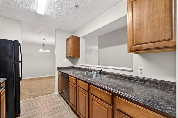a kitchen with granite countertop stainless steel appliances a sink and a counter space