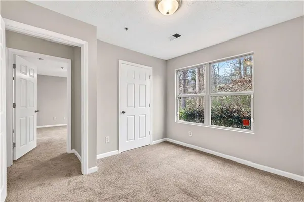 an empty room with windows and closet