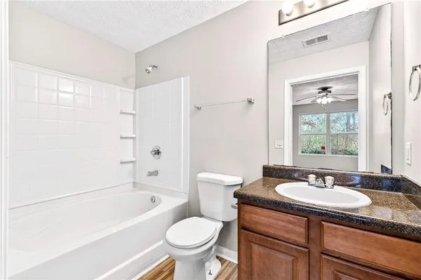 a bathroom with a granite countertop sink toilet and shower