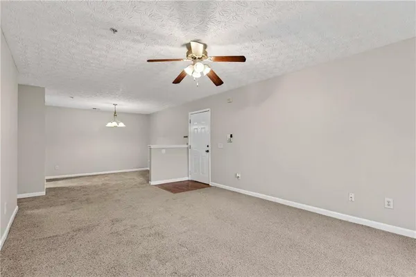 an empty room with chandelier fan