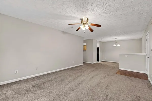en view of a big room with a ceiling fan and chandelier fan