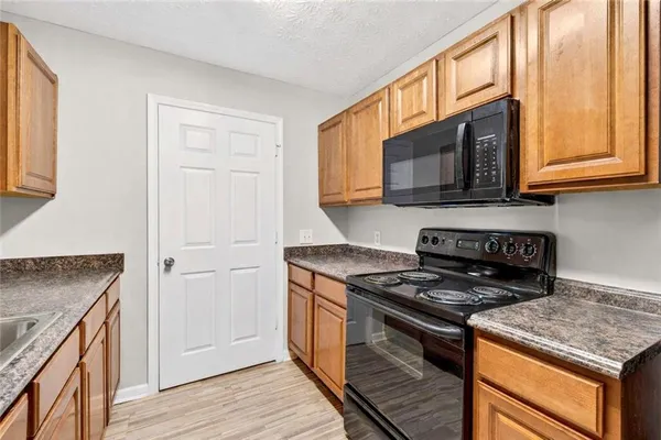 a kitchen with stainless steel appliances granite countertop a stove microwave and sink