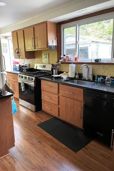 9561 Harding Road Pittsburgh, PA 15237 - Photo 5 of 9 a kitchen with stainless steel appliances granite countertop wooden floors a stove top oven and a view of living room