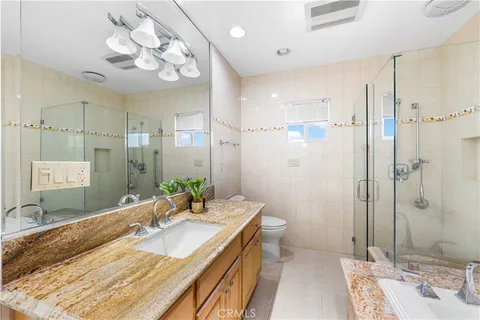 a spacious bathroom with a double vanity sink mirror and shower