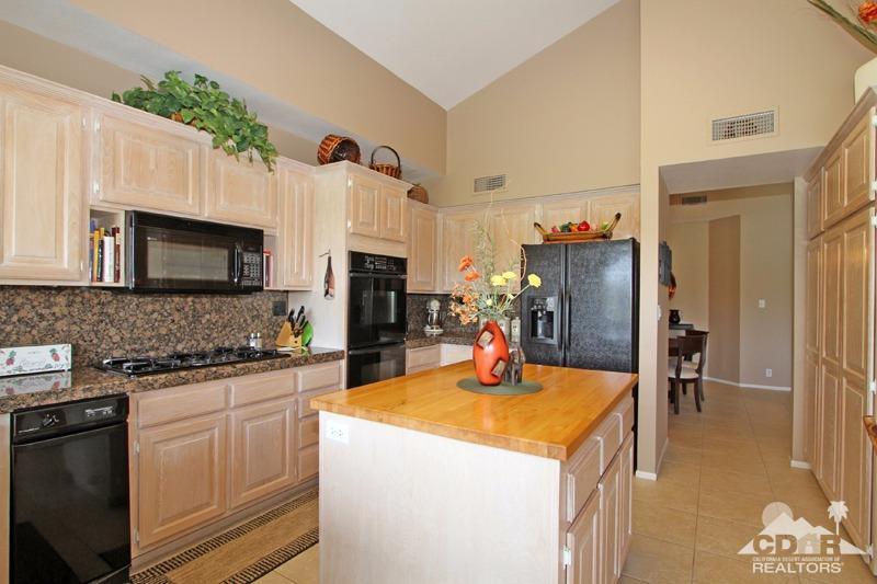 332 Red River Road Palm Desert, CA 92211 - Photo 16 of 40 a kitchen with a refrigerator and a stove top oven
