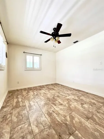a view of a hallway with wooden floor and a bathroom