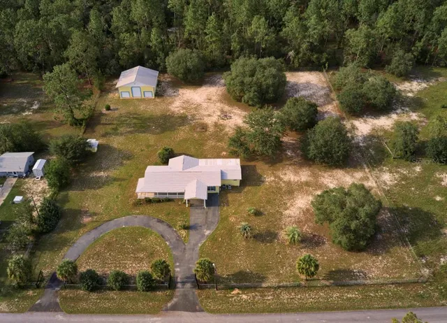 an aerial view of a house with a yard