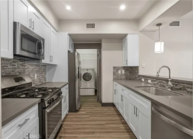 a kitchen with stainless steel appliances granite countertop a stove and a sink