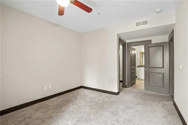 an empty room with a ceiling fan and closet