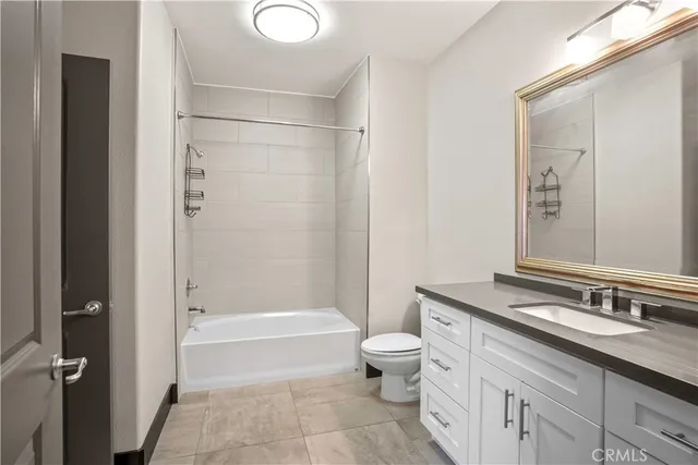 a bathroom with a granite countertop sink a toilet and shower