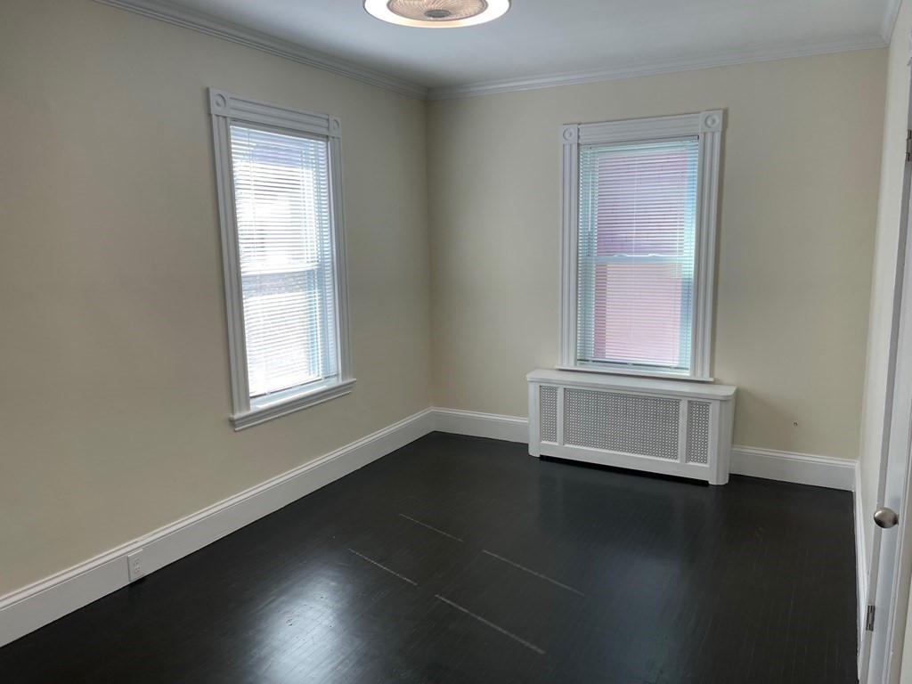 840 South Street, Unit 1 Boston, MA 02131 - Photo 14 of 19 an empty room with wooden floor and windows