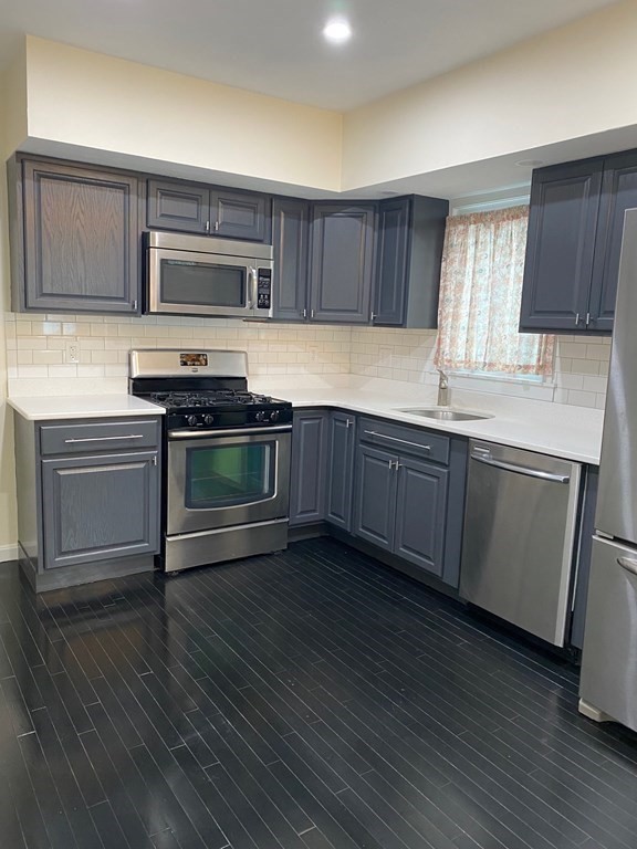840 South Street, Unit 1 Boston, MA 02131 - Photo 2 of 19 a kitchen with stainless steel appliances granite countertop a sink a stove a refrigerator and cabinets