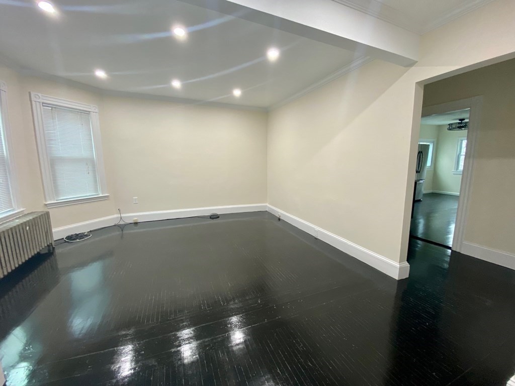 840 South Street, Unit 1 Boston, MA 02131 - Photo 4 of 19 an empty room with wooden floor and windows