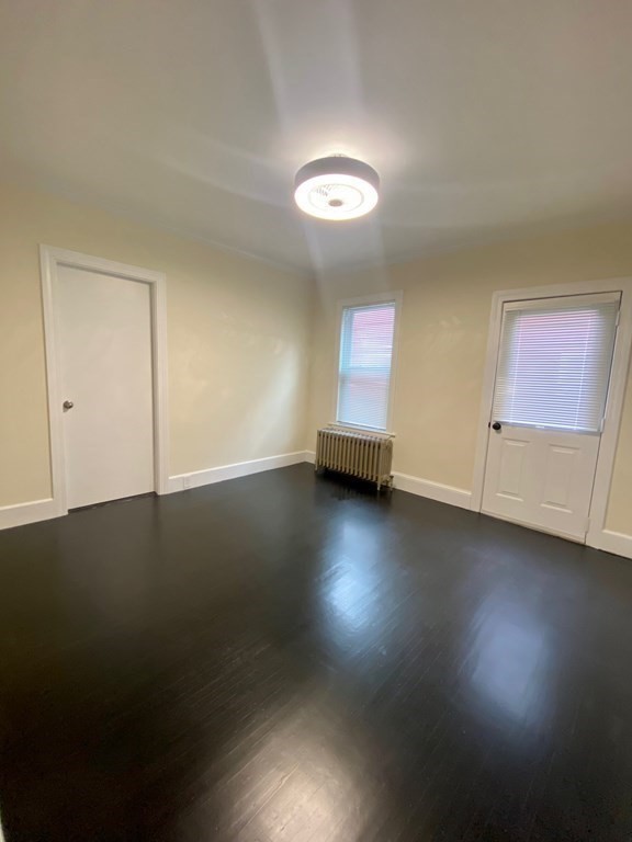 840 South Street, Unit 1 Boston, MA 02131 - Photo 8 of 19 an empty room with wooden floor and windows