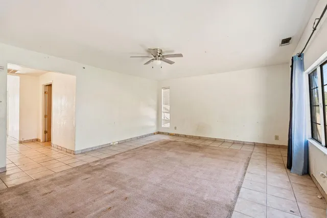 a view of an empty room with a ceiling fan