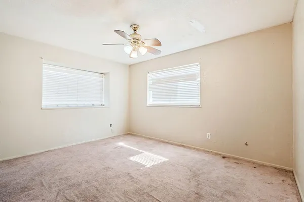 an empty room with closet and ceiling fan