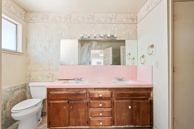 a bathroom with a granite countertop sink a toilet and a mirror